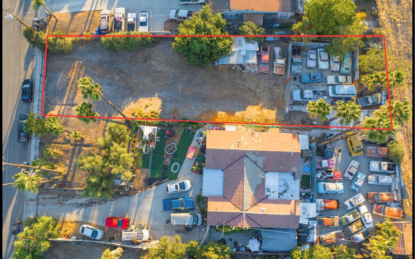 Aerial drone view of a two-unit investment property and its lot, outlined in red, in Riverside, California