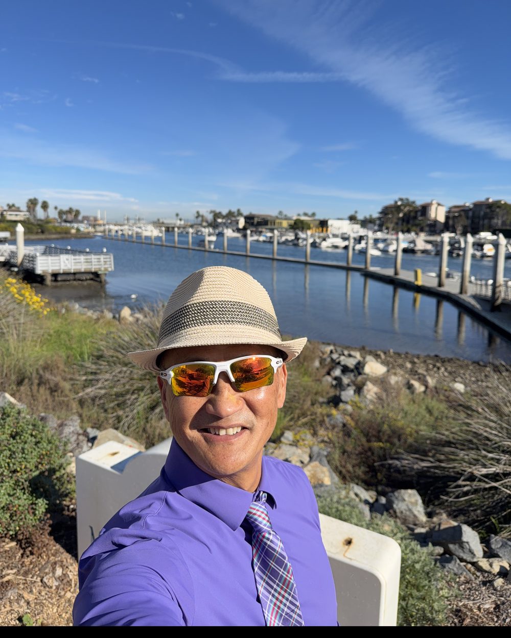 Kiri Suykry at Huntington Harbour, with boats and waterfront homes behind him